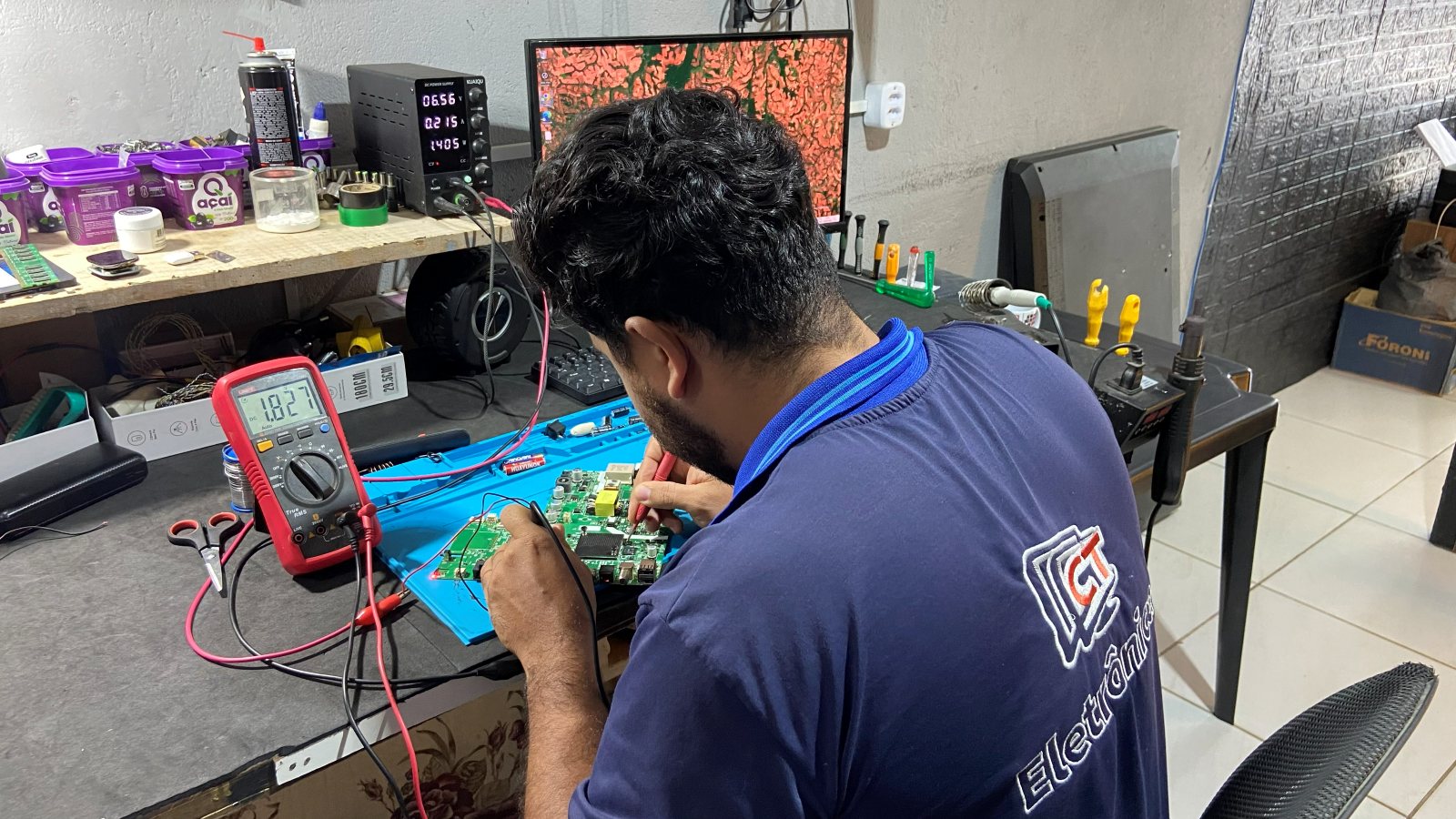 Técnico da CT Eletrônica consertando uma placa na bancada